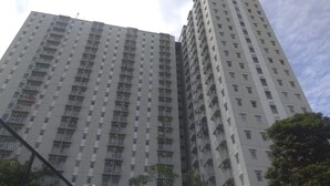 Un edificio residenziale alto con diversi piani, balconi e cielo sereno.