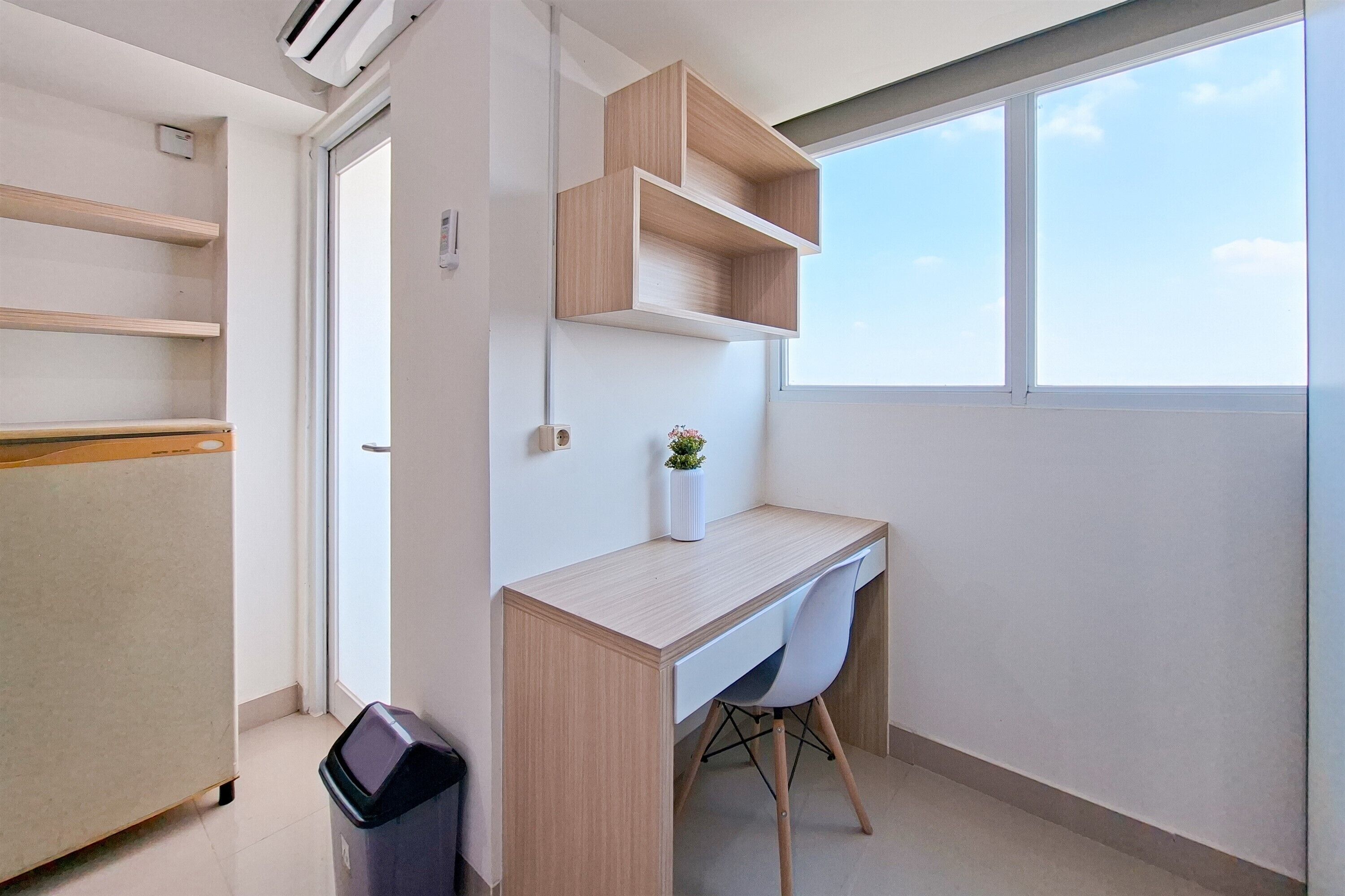 Une petite pièce moderne, équipée d’un bureau, d’étagères et d’une fenêtre.