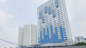 Een hoog gebouw met een modern architectonisch ontwerp, met een opvallende blauwe gevel en meerdere balkons.
