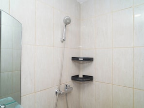 A shower with a handheld showerhead and a wall-mounted faucet. There is a black shelf attached to the wall. - Comfortable Space And Neat Studio At Apartment Citra Living (Jakarta)