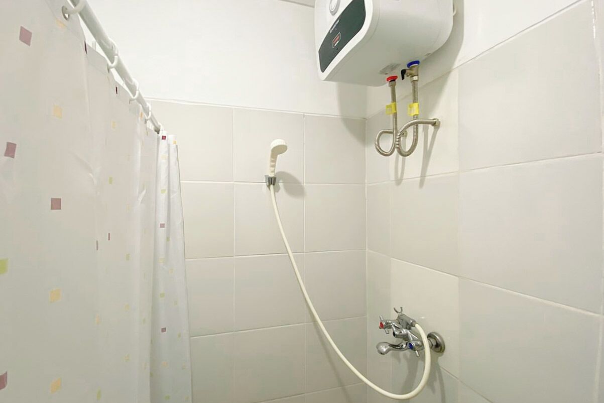 Ducha con cabezal de ducha manual, grifo de pared y panel de control en la pared.
