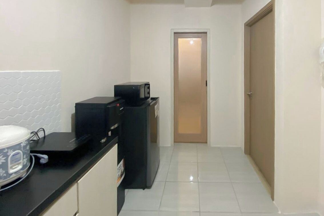 A kitchen with a microwave, a kettle, and a coffee maker on the counter.