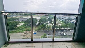 Un balcón con vistas a un paisaje urbano, con edificios y zonas verdes.