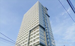 A tall, modern building with a grid-like facade and multiple balconies. - Homely And Pleasant Studio At Apartment De Prima (Medan)
