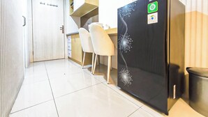 Een kleine keuken met een koelkast, een spoelbak en een aanrecht.