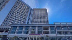 Un edificio moderno con varios pisos, ventanas amplias y un letrero llamativo que dice 'DELETT'.