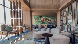 Un vestíbulo moderno con un mural grande, zonas de estar y un diseño de pared único.