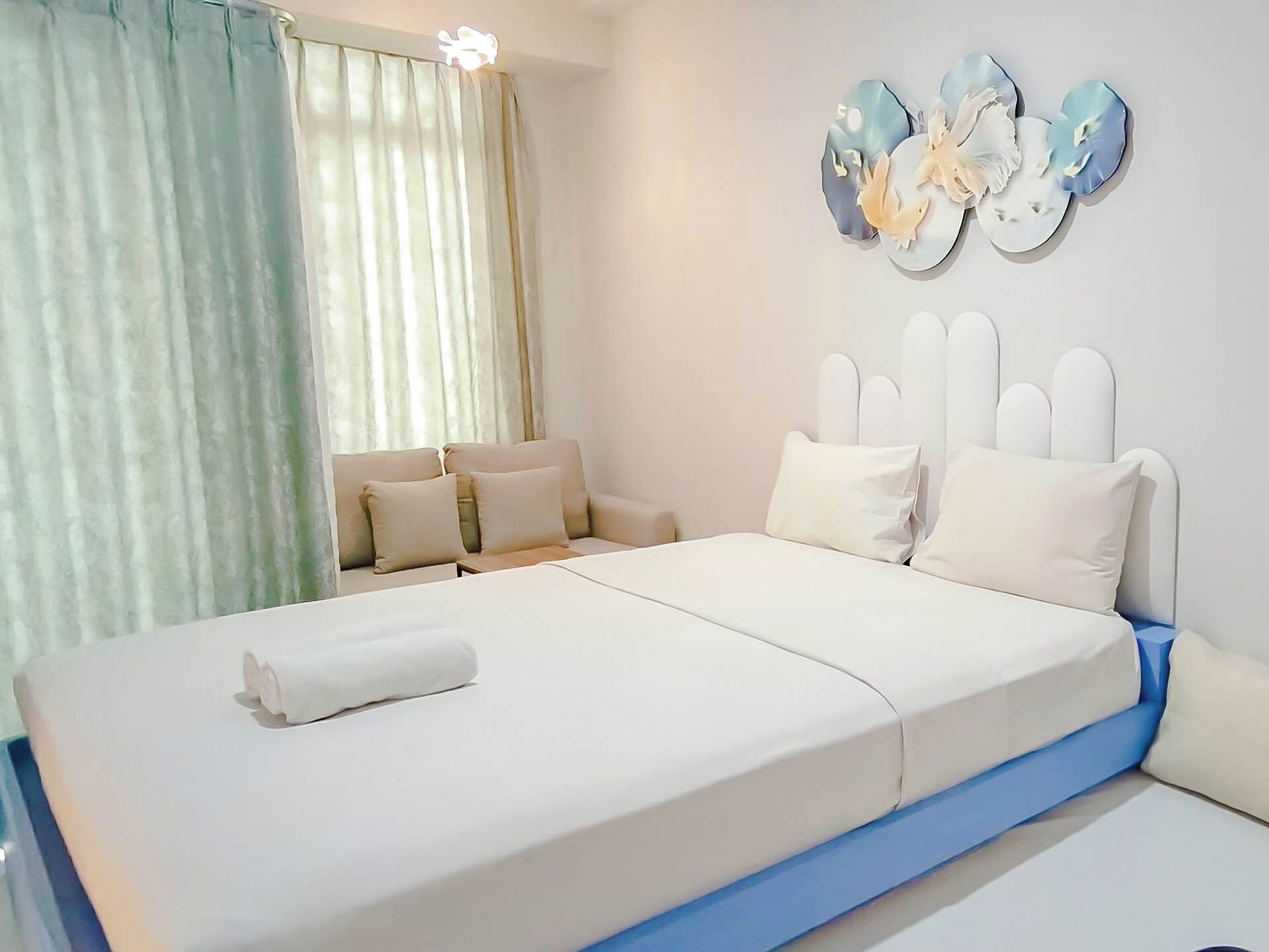 A bedroom with a bed, a sofa, and a wall-mounted decoration.