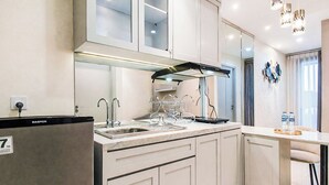 A modern kitchen with a built-in stove, a sink, and a dishwasher. - Artistic And Bright 1Br At Grand Sungkono Lagoon Apartment (Surabaya)
