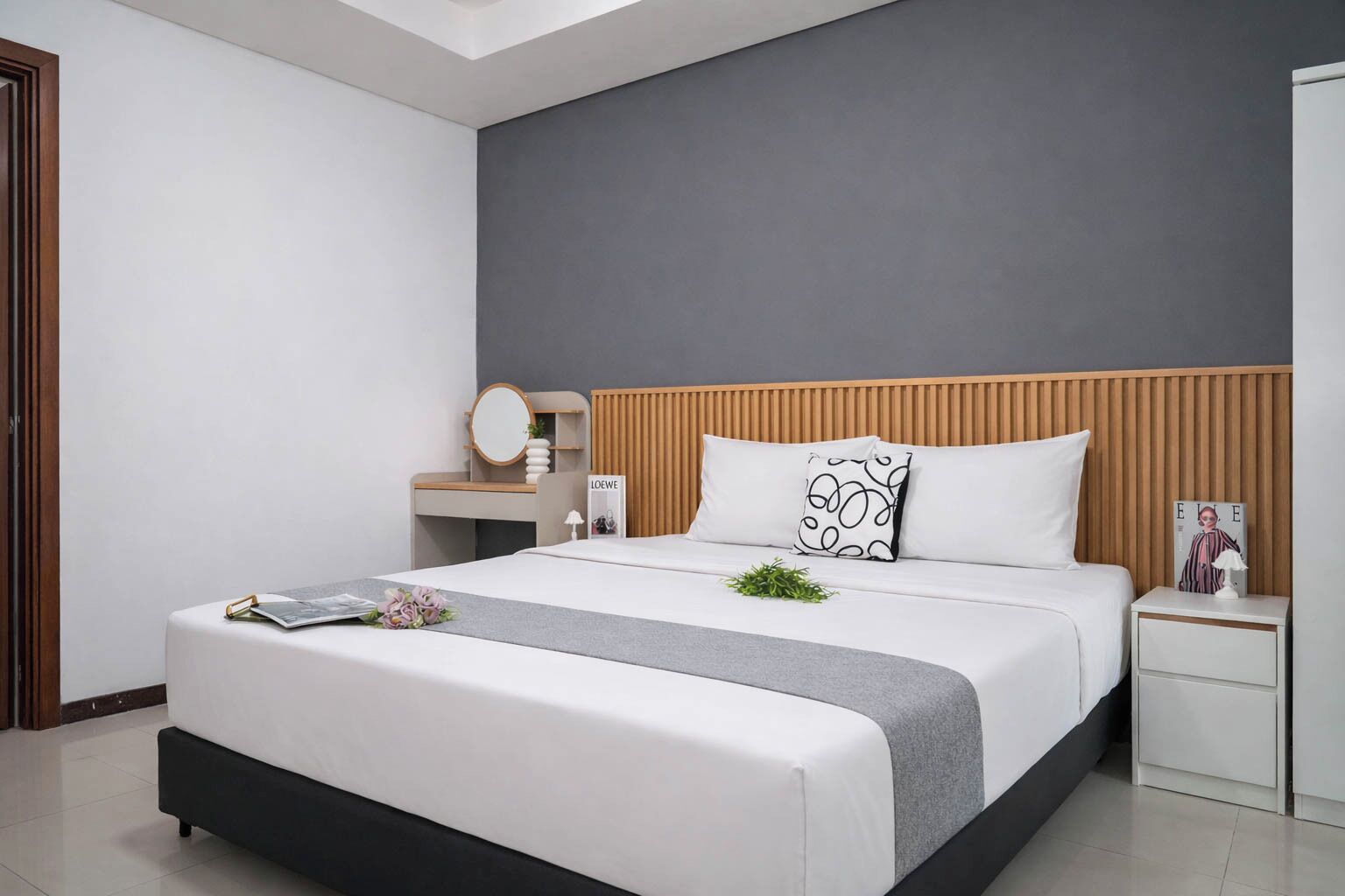 Un dormitorio moderno con cama, mesitas de noche, cómoda y espejo.