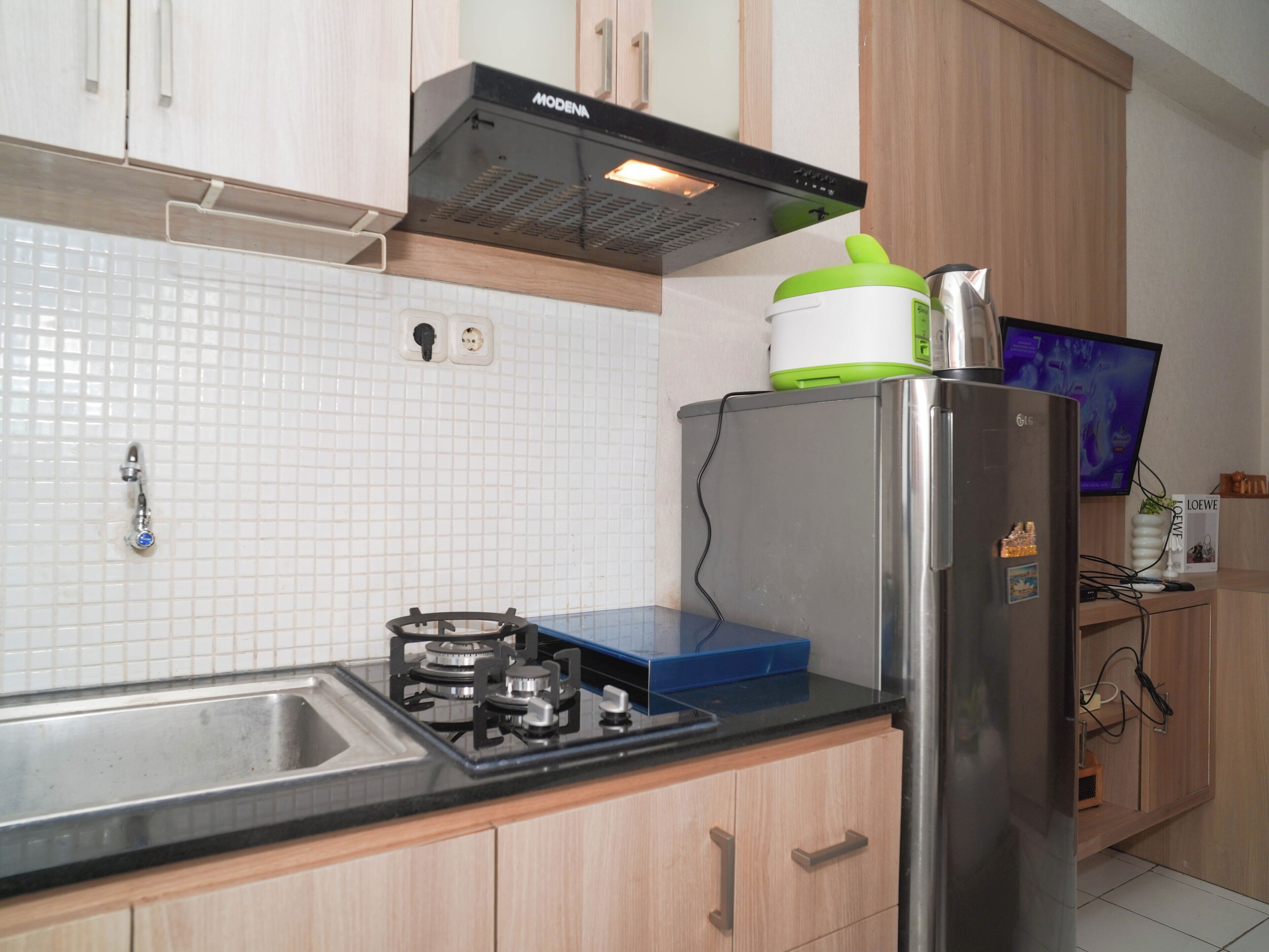 A kitchen with a gas stove, a refrigerator, a microwave, and a sink.