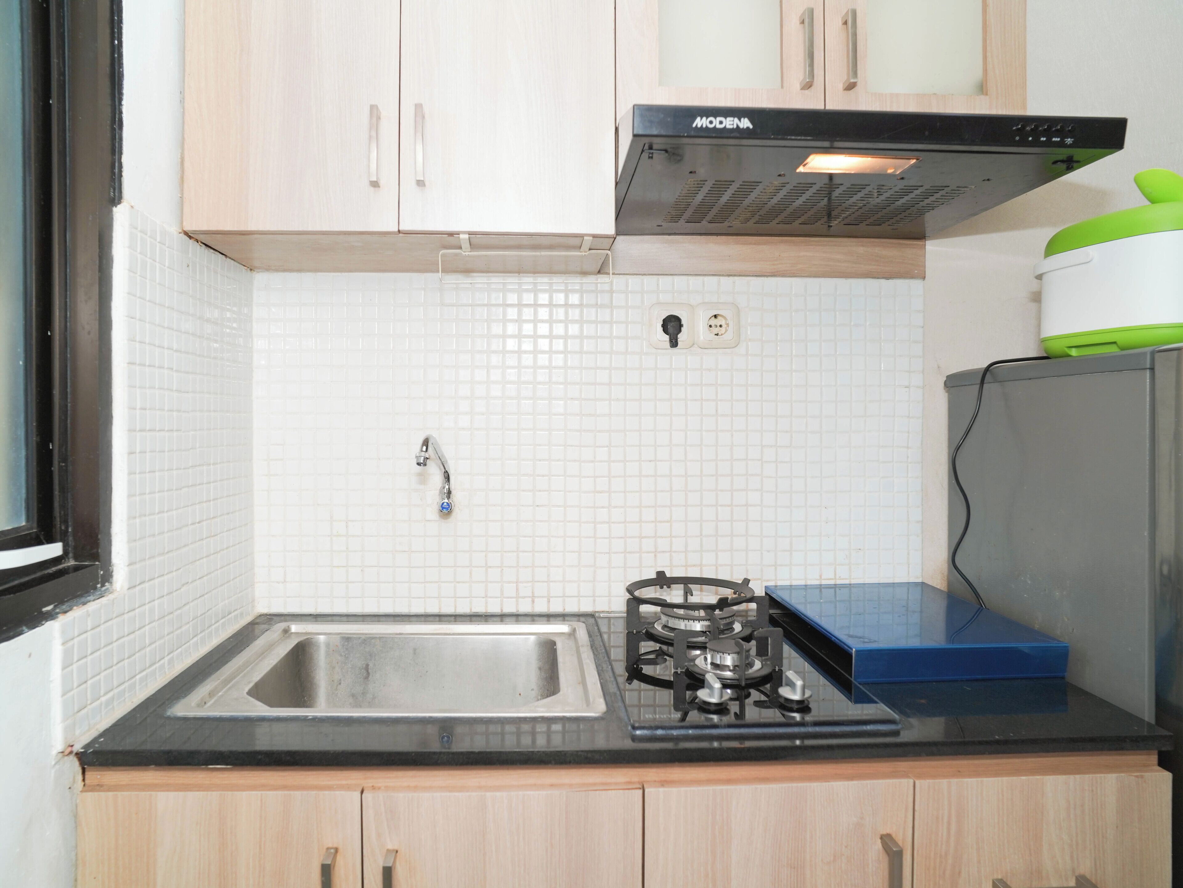 A kitchen with a gas stove, a sink, and wooden cabinets.