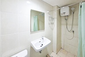 A bathroom with a sink, mirror, shower, and tiled walls. - Great Deal Studio Apartment At M-Town Residence (Gading Serpong)