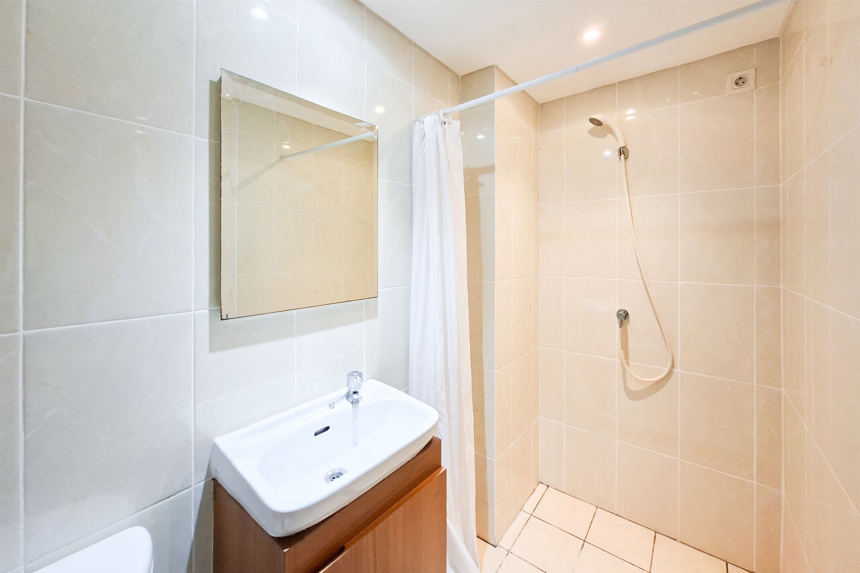 A modern bathroom with a shower, a sink, and a mirror.