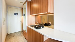 Eine moderne Küche mit Holzschränken, einer weißen Arbeitsplatte, einem Spülbecken und einem Herd.