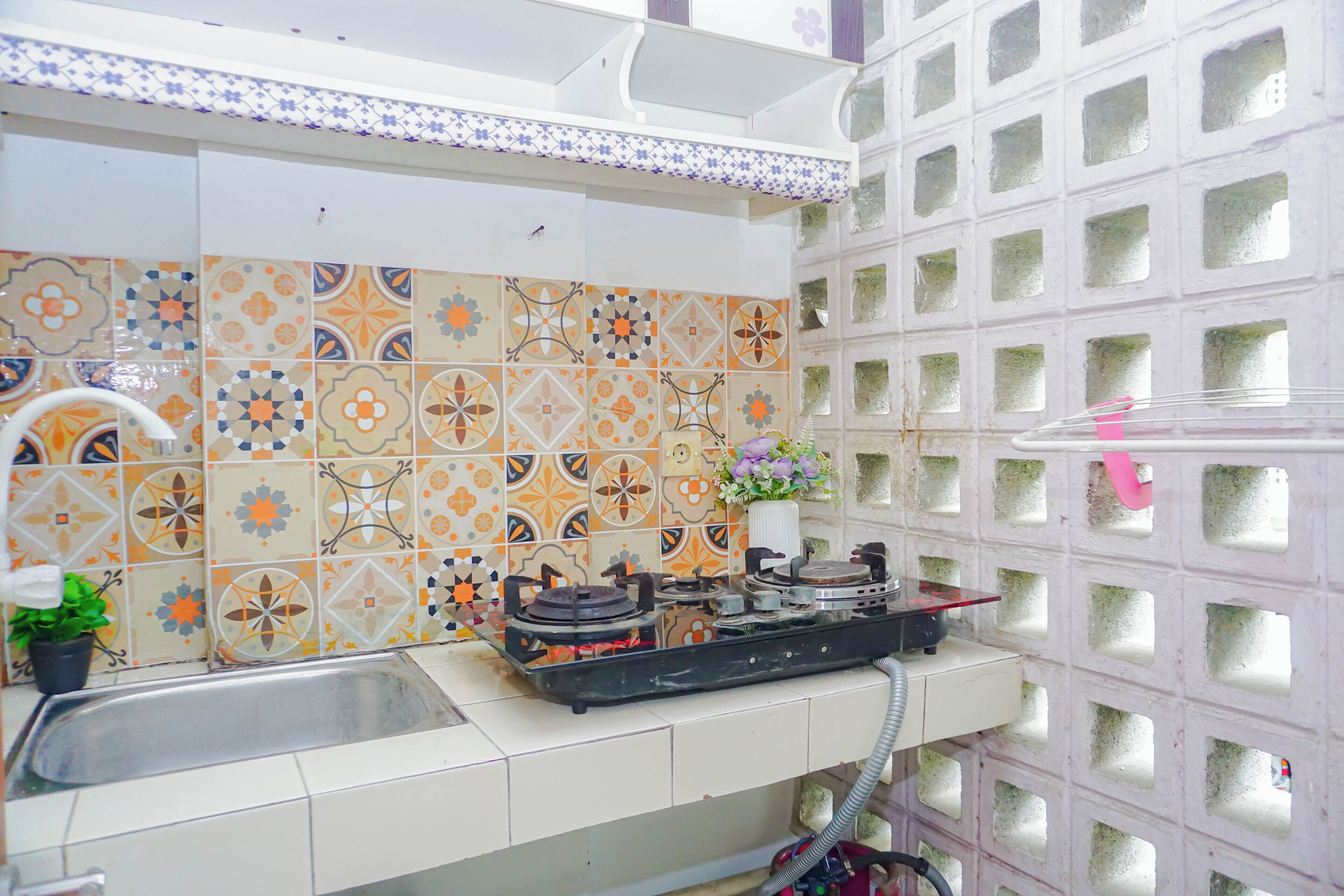 A kitchen with a gas stove, a sink, and a decorative backsplash.