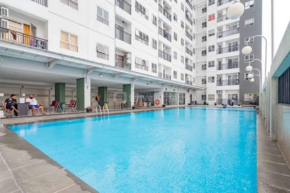 A swimming pool with a covered area, adjacent to a multi-story residential building. - 2Br At Mekarwangi Square Cibaduyut Apartment (Bandung)
