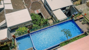 An aerial view of a swimming pool surrounded by buildings, with a clear sky above. - Wonderful Studio At Apartment Nifarro Park Near Pasar Minggu Station (Jakarta)