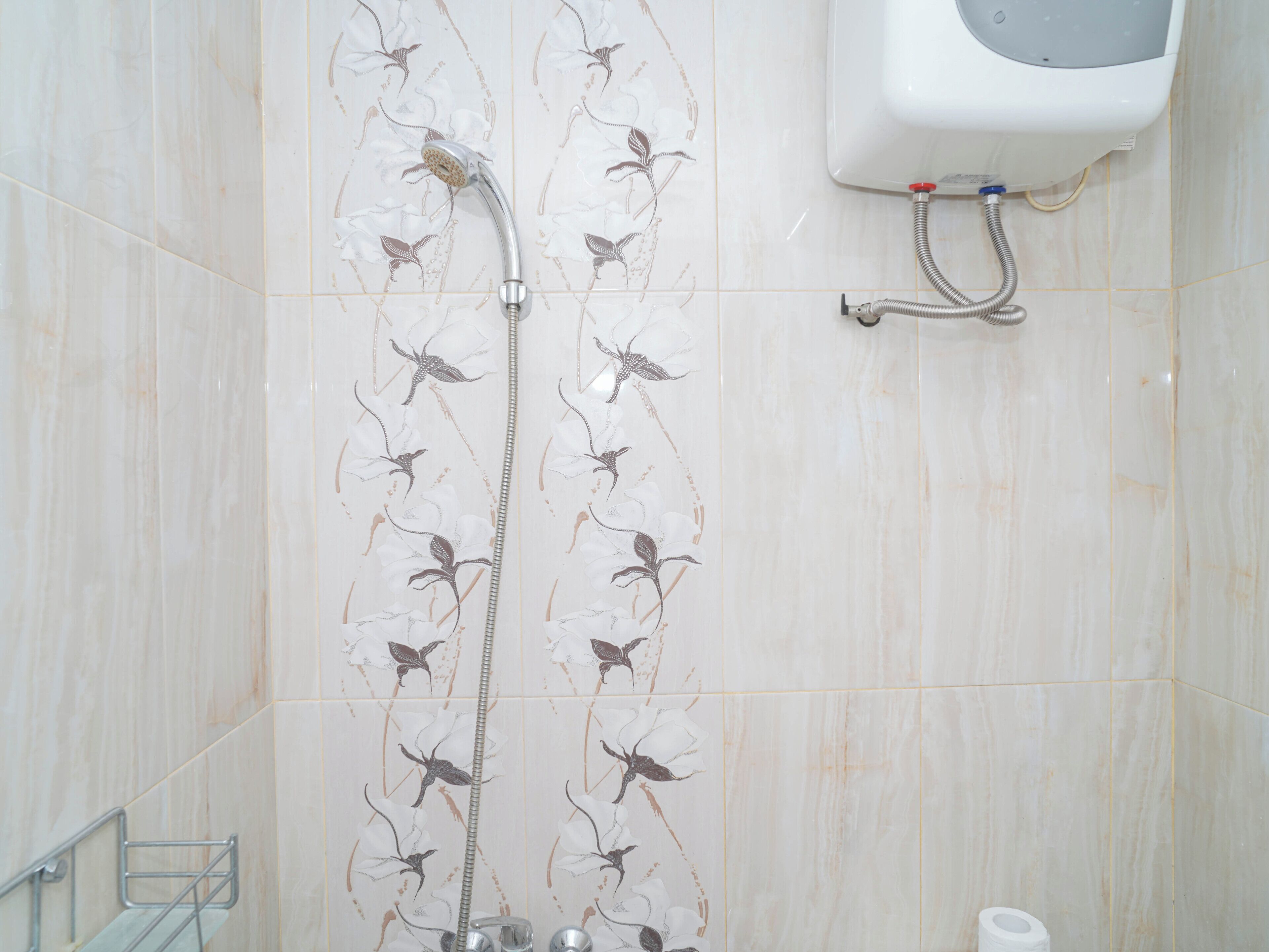 A bathroom with a shower, toilet, and hand dryer.