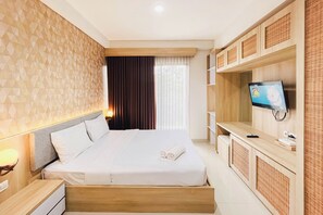 Une chambre d’hôtel équipée d’un lit, d’une télévision, d’un bureau et d’une armoire.