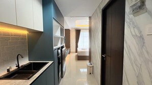 Eine moderne Küche mit integriertem Spülbecken, einer Mikrowelle und einem kleinen Kühlschrank.