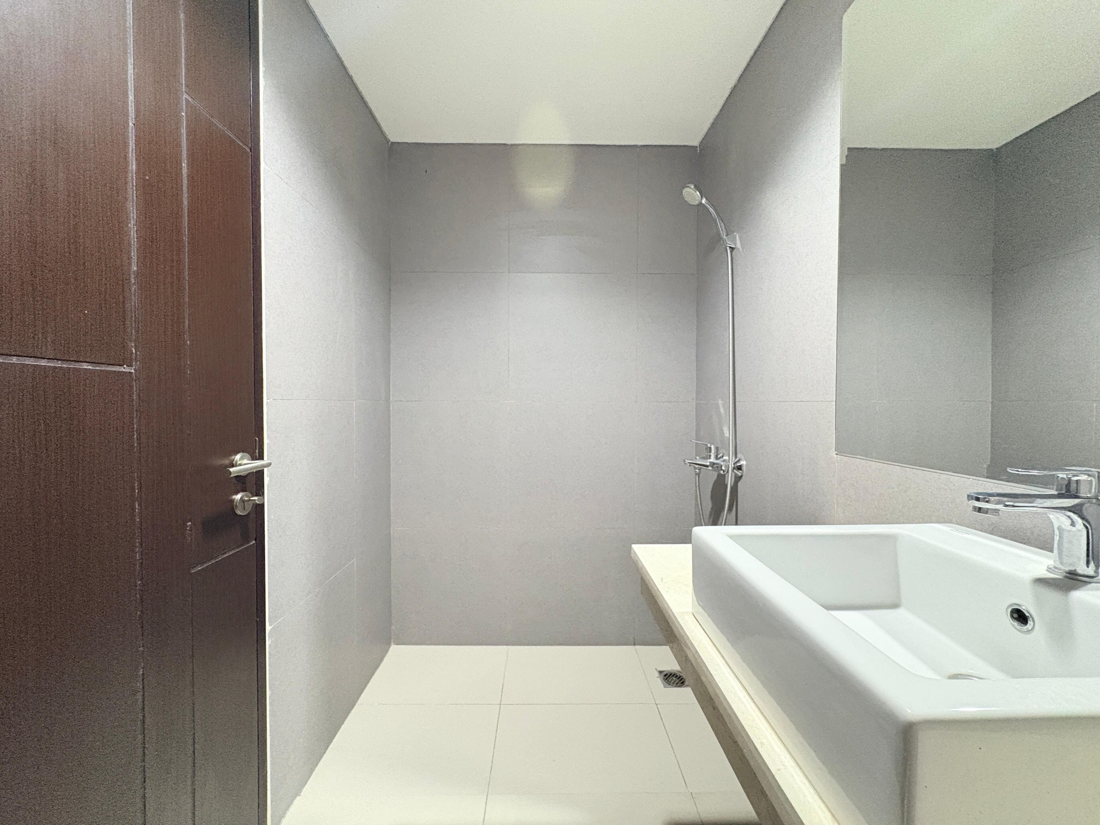Un baño con ducha, lavabo y espejo.