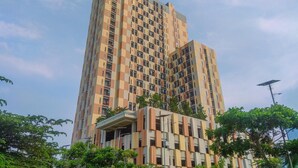 A multi-story building with a modern architectural design, featuring a mix of balconies and windows. - Modern Japandi Studio At Sayana Bekasi Apartment (Bekasi)