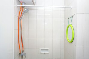 A shower with a handheld showerhead and a green rubber ring on the wall. - Damask Style Studio At Signature Park Grande Apartment (Jakarta)