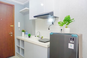 Una cocina con refrigerador, lavamanos y armarios.