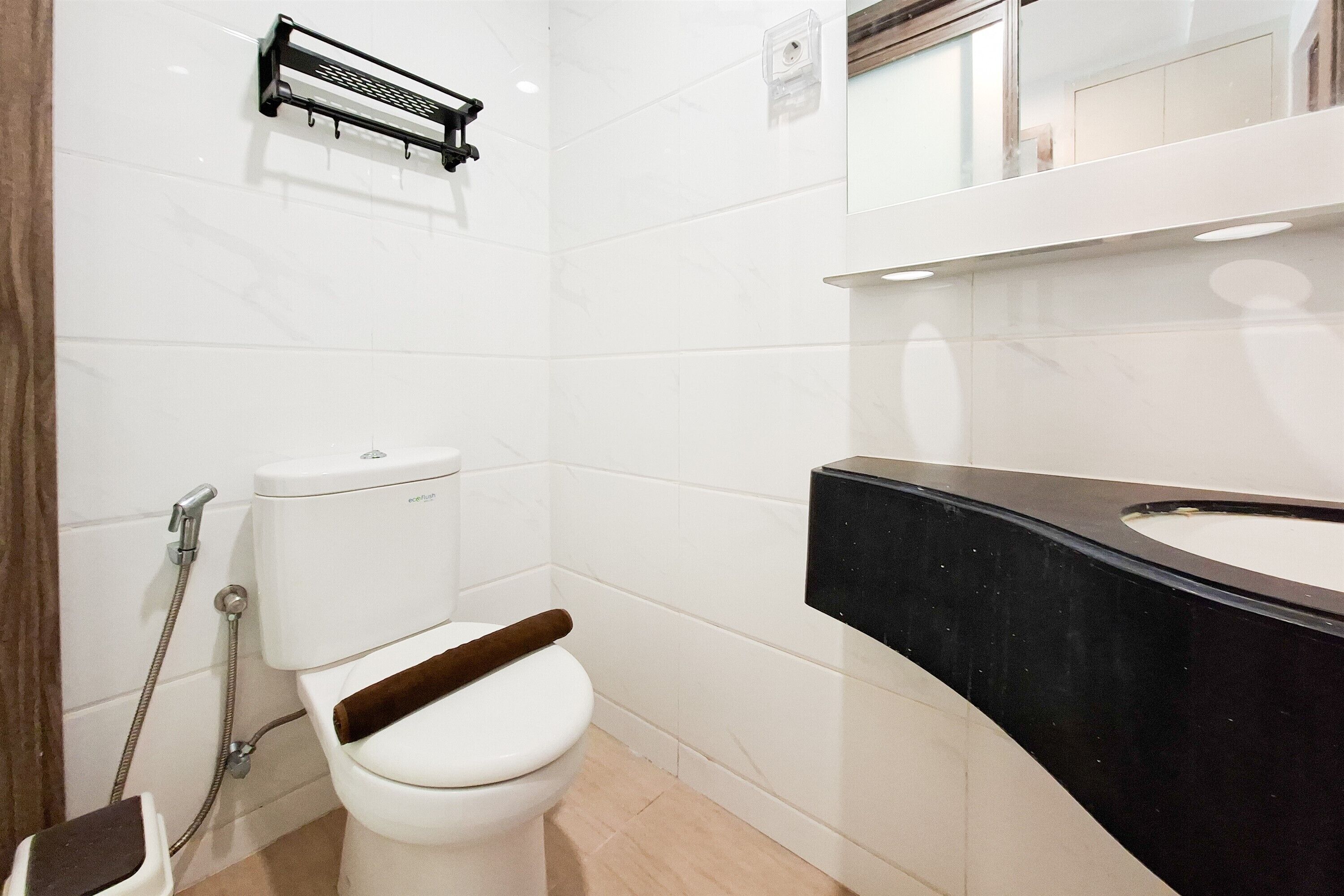 A modern bathroom with a toilet, shower, and sink.