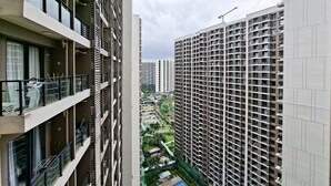 A high-rise residential building with multiple balconies, a swimming pool, and a landscaped area. - White Tone Studio For 2 Pax At Sky House Bsd Apartment (Pagedangan)
