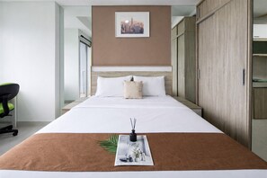 A hotel room with a bed, a desk, and a wardrobe. - Cozy Studio Room Apartment Springwood Residence Tangerang (Tangerang)