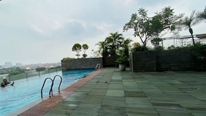 An outdoor swimming pool with a view of the cityscape. - Neat 2Br For 3 Pax At Tamansari Papilio Apartment (Surabaya)