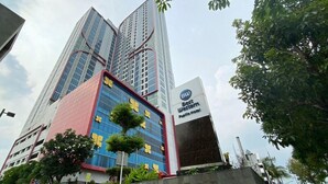 A hotel with a modern design, featuring a prominent Best Western sign and a large glass facade. - Neat 2Br For 3 Pax At Tamansari Papilio Apartment (Surabaya)