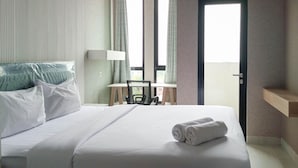Una camera d'albergo con un letto, una scrivania, una sedia e una porta.