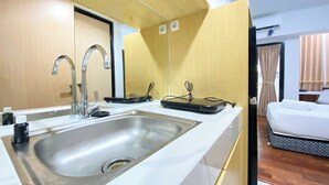 A hotel room with a modern kitchen area, a large sink, and a bed with a mattress on the floor. - Modern Look Studio At The Alton Apartment (Semarang)