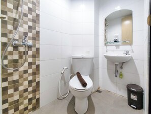 A bathroom with a toilet, a shower, a sink, and a trash bin. - Modern Look Studio At The Alton Apartment (Semarang)