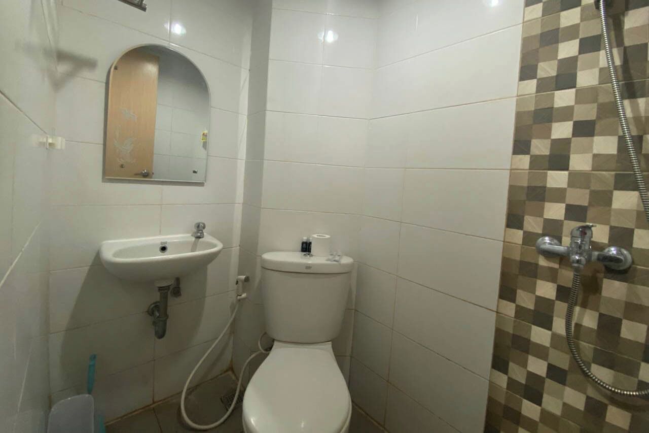 A bathroom with a toilet, sink, and shower.