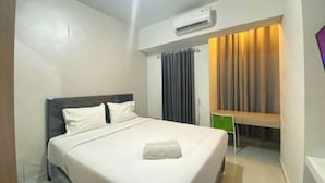 Une chambre d’hôtel équipée d’un lit, d’un bureau, d’un appareil de climatisation et d’un rideau.