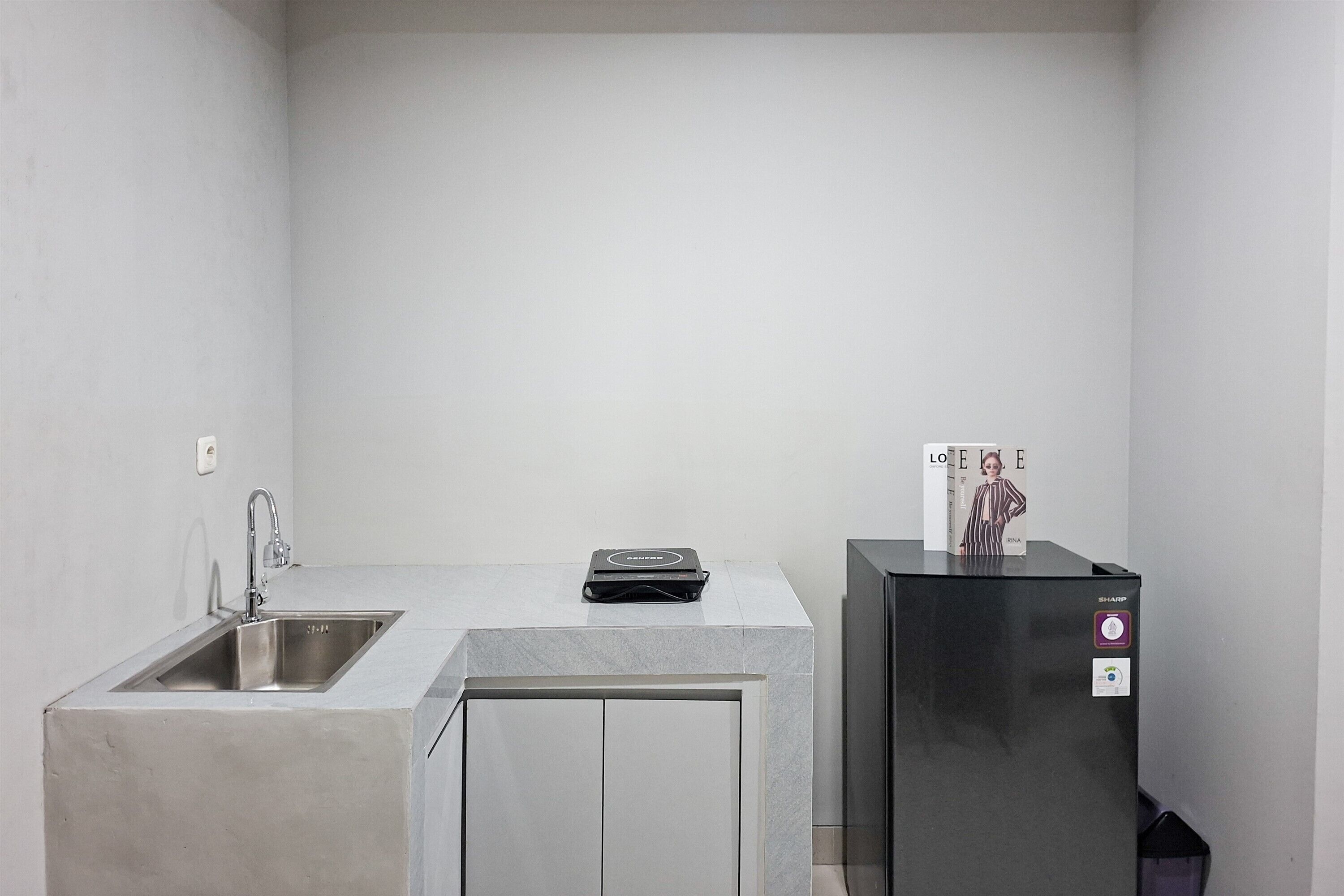 A compact kitchen with a sink, a countertop, and a refrigerator.