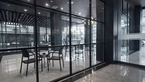 Un interior moderno con ventanas amplias, suelos reflectantes y mobiliario contemporáneo.