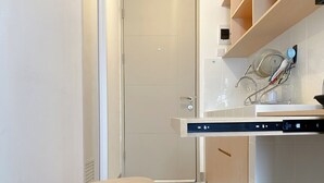Et moderne køkken med opvaskemaskine, en lille skammel og et opvaskestativ.