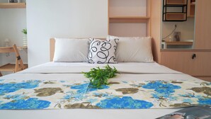 A neatly arranged bedroom with a bed, a small desk, and a mirror. - Compact And Contemporary Studio Apartment Tokyo Riverside Pik 2 (Teluknaga)