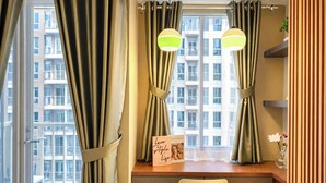 A room with a desk, two lamps, a chair, a window with curtains, and a sign on the desk. - Nice Space And Pleasant Studio At Apartment Tokyo Riverside Pik 2 (Teluknaga)