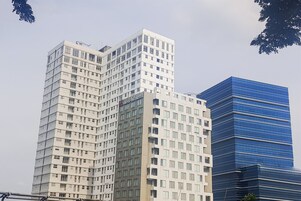 Un edificio alto de varios pisos con un diseño moderno, que presenta un letrero destacado para Swissotel.