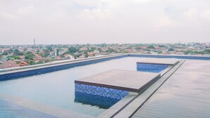 Una piscina en la azotea con vista a una zona residencial.