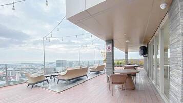 A modern outdoor terrace with seating and a city view.