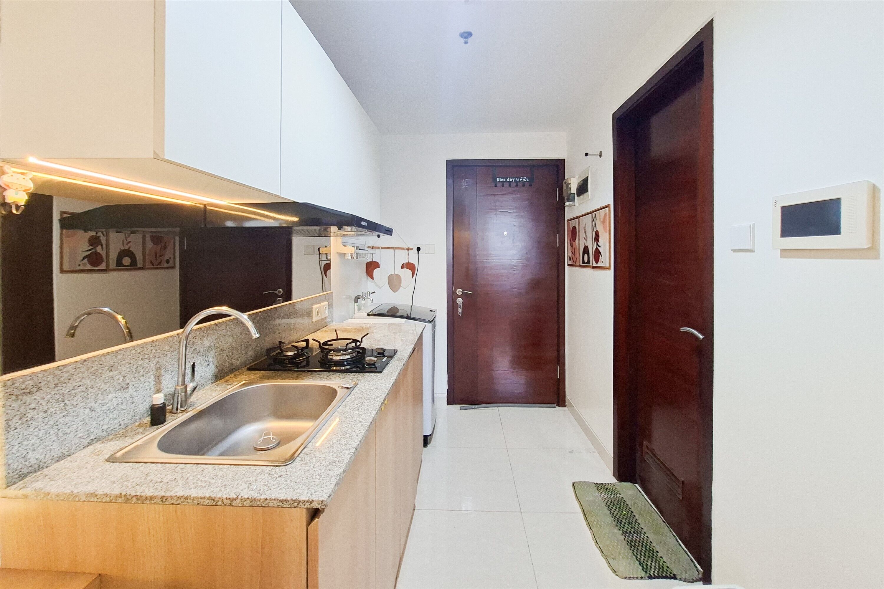 A narrow kitchen with a granite countertop, stainless steel sink, and a stove.