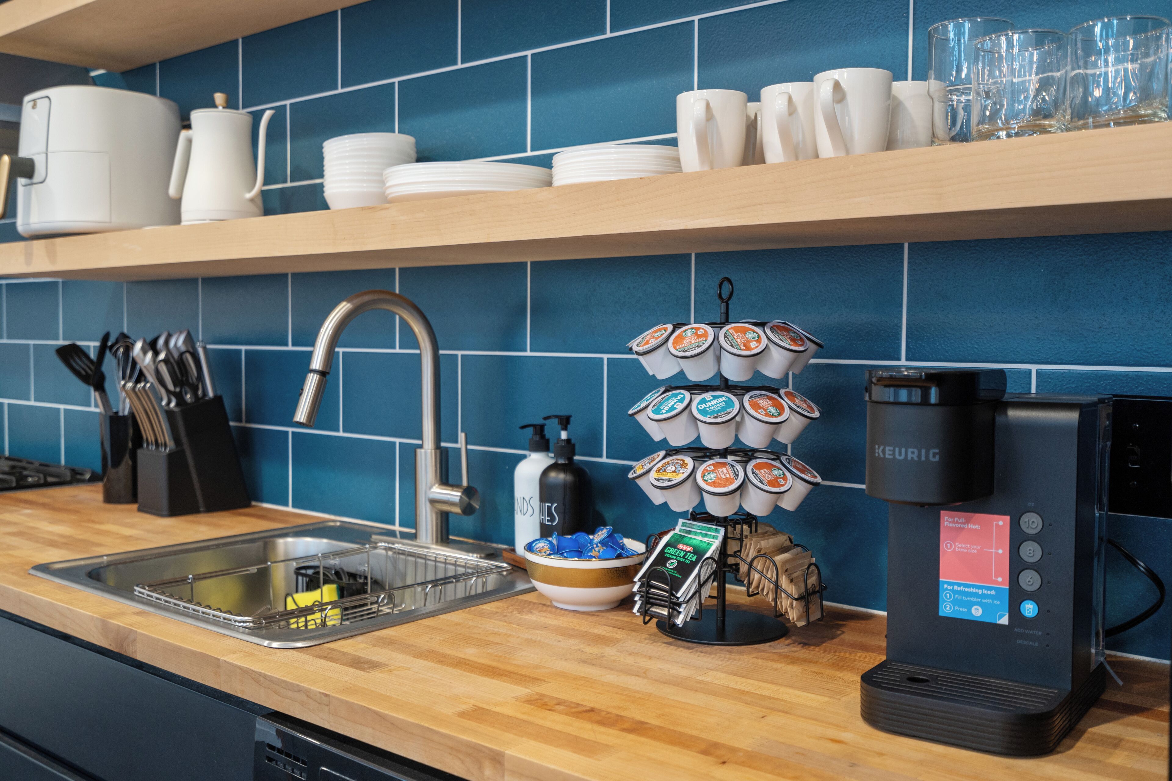 A kitchen counter with a coffee machine, a dish rack, and a bowl of snacks.