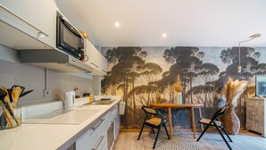 Uma cozinha moderna com micro-ondas, pia e área de refeições com cadeiras e mesa.